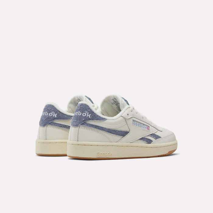 A pair of Reebok Women's Club C Revenge Shoes in white with blue suede accents, shown from the back and side on a plain light background.