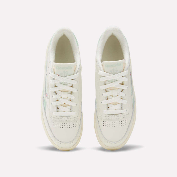A pair of Women's Club C Revenge Vintage Shoes by Reebok in white with light green accents, shown from above. Features include white laces, perforated toe boxes, and the visible Reebok logo on the tongues.