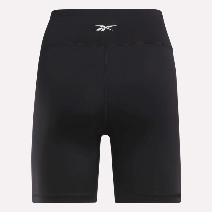 Reebok Women's Core High-Rise Cycle Shorts feature a small white logo on the waistband. Made from smooth, stretchy, sweat-wicking fabric, they're perfect for cycling or workouts. Shown against a plain light background.
