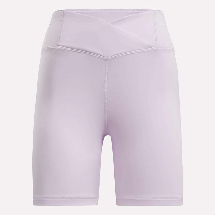 Women's Core High-Rise Cycle Shorts by Reebok in light purple, featuring a crossover waistband and visible stitching, made from sweat-wicking fabric. Shown against a plain white background.