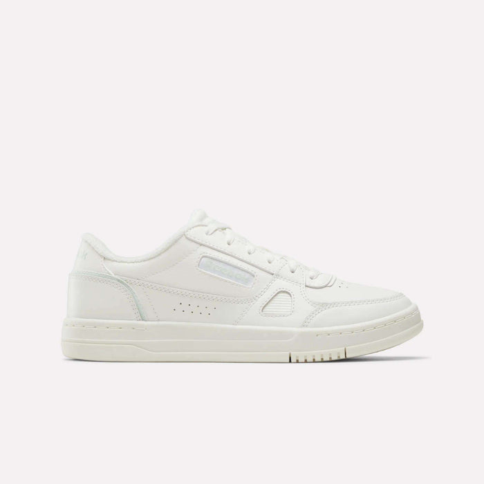 A women’s low-top sneaker in Chalk/Dew/White, crafted from full grain leather with subtle stitching, perforations, and a textured sole, displayed on a plain light background and shown from the side. These Reebok Women’s Court LXS Shoes embody the refined style of classic court footwear.