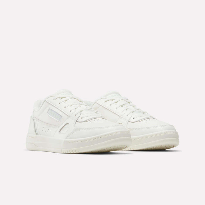 A pair of white low-top Women’s Court LXS Shoes by Reebok, crafted from premium full grain leather with laces, side stitching detail, and textured soles—perfect court shoes for women displayed on a plain white background.