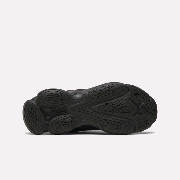 Bottom view of the Women's DMX Series 3000 Training Shoes by Reebok, showing a black textured rubber outsole with curved, leaf-like treads on a white background—ideal for walking and offering cushioned comfort.