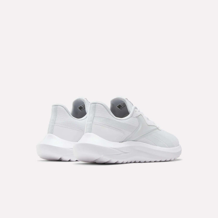 The Reebok Women's Energen Lux Running Shoes are shown in white from the back and side on a plain light background, highlighting their versatile style, thick textured soles, and comfort.