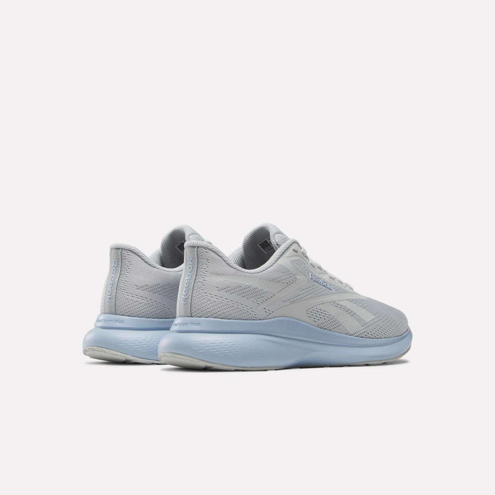 A pair of Women's Energen Run 4 Running Shoes by Reebok in light gray with breathable mesh uppers and light blue soles and laces, shown from the back and side against a white background.