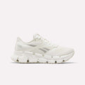 Side view of a white Reebok Women's FloatZig 2 Running Shoe featuring a mesh upper, unique angular outsole, and energy-return cushioning for comfort.