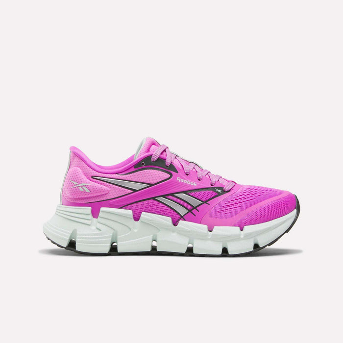 The Reebok Women's FloatZig 2 Running Shoes in bright pink feature black and white accents, energy-returning cushioning, a supportive breathable mesh upper, a white segmented sole, and visible Reebok logos on the side and heel.