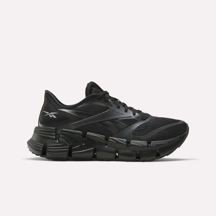 The Reebok Women's FloatZig 2 Running Shoes feature a black mesh upper, sleek design, and chunky segmented sole with Superfloat+ cushioning for energy return, shown in a side view against a white background.