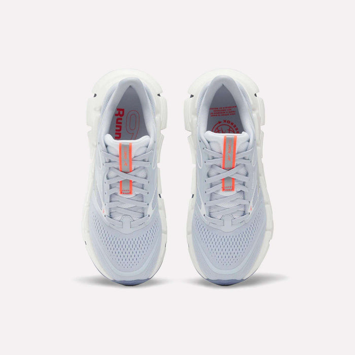 Top view of Reebok Women's FloatZig 2 Running Shoes with light gray mesh uppers, Superfloat+ cushioning for a springy feel, white soles, and orange accents on the tongue and insole, placed side by side on a plain background.