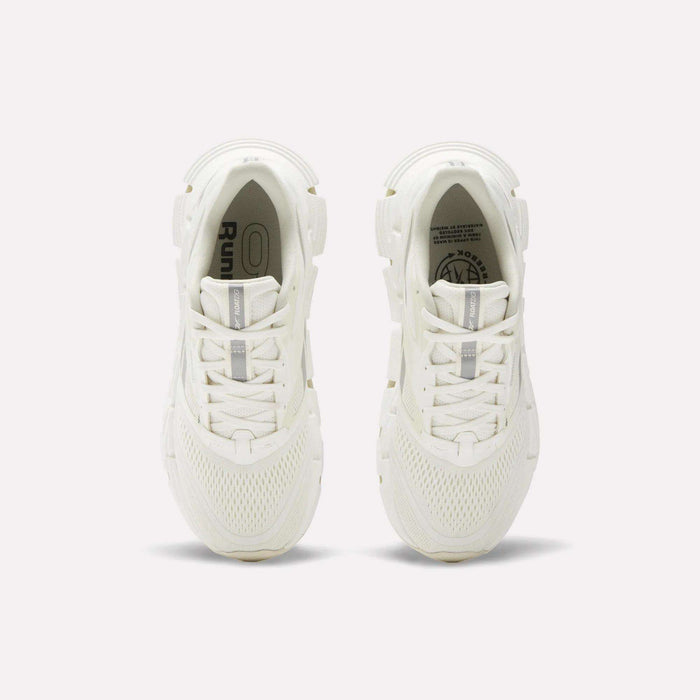 A pair of women's Reebok FloatZig 2 running shoes in white, seen from above, showcase mesh uppers, laces, and subtle Reebok branding on the insoles and tongue, with energy-returning cushioning against a plain light background.