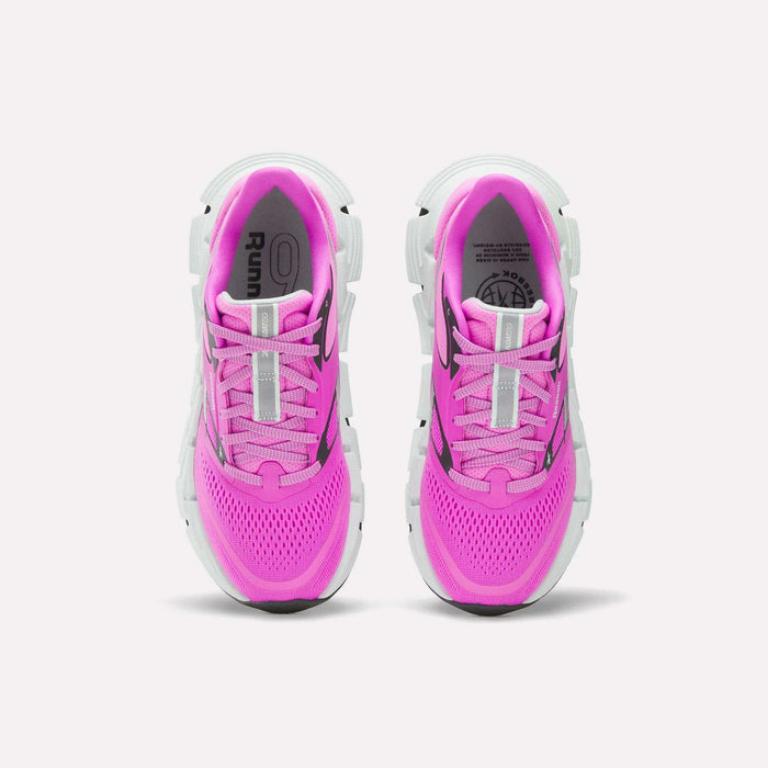 The Reebok Women's FloatZig 2 Running Shoes, shown from above on a white background, feature a bright pink upper with energy-returning cushioning, supportive design, white soles, and black accents.