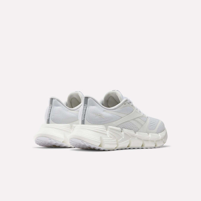 A pair of white Reebok Women's FloatZig 2 Running Shoes with chunky soles and Superfloat+ cushioning, shown from the back and side against a plain white background.