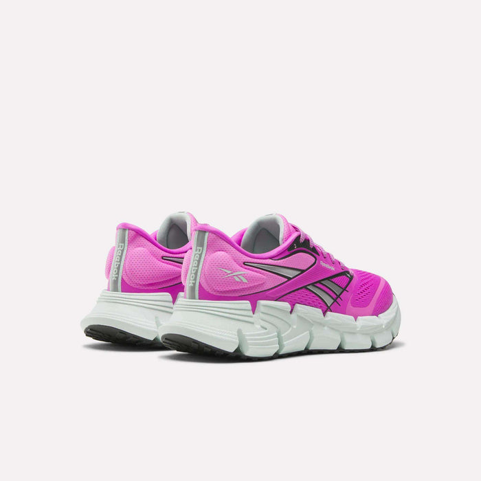 The Reebok Women's FloatZig 2 Running Shoes are shown in pink with a supportive upper, white soles, and black accents. The shoes are displayed from the back and side on a plain white background.