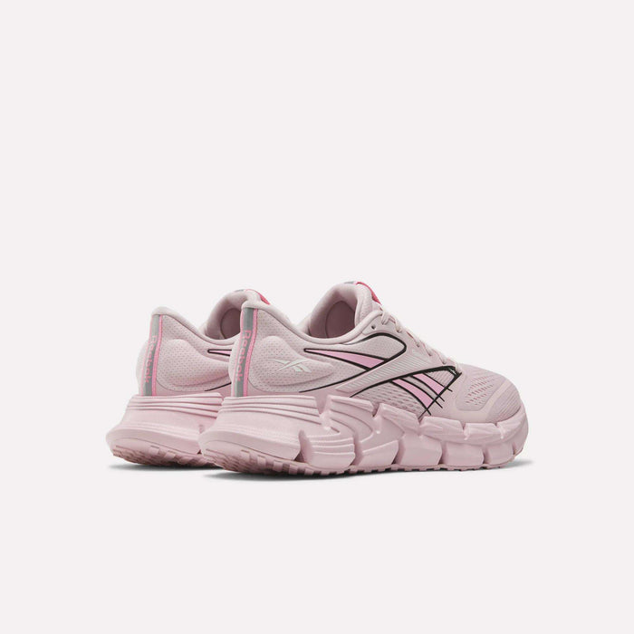 A pair of light pink Reebok Women's FloatZig 2 Running Shoes with chunky soles, black and pink striped side logos, subtle heel branding, and Superfloat+ cushioning for a springy run. Shown on a plain white background.