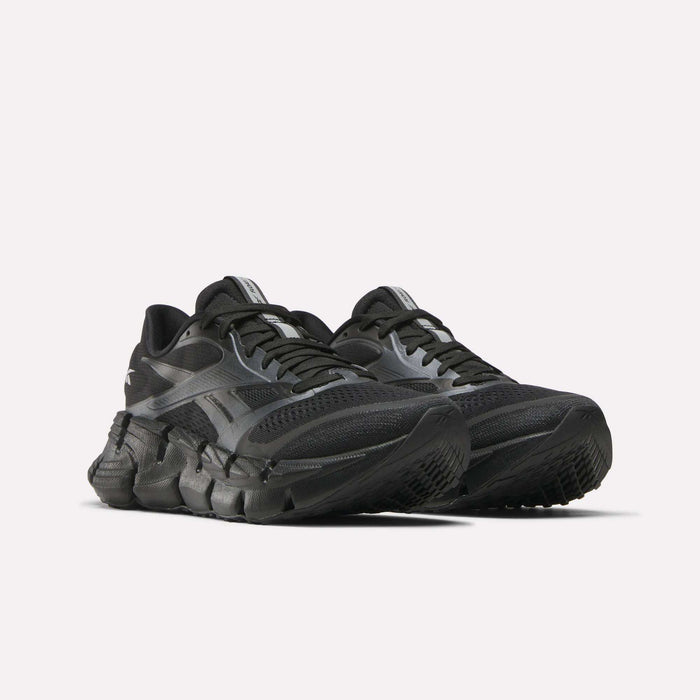 A pair of Reebok Women's FloatZig 2 Running Shoes with Superfloat+ cushioning, textured sole, mesh upper, and sleek black design for energy-returning comfort, shown side by side on a plain white background.