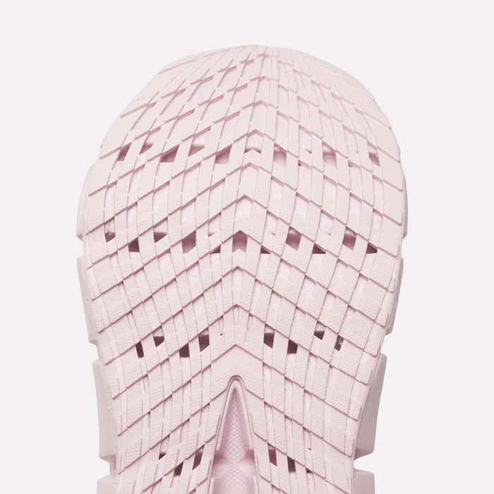 Close-up of a light pink Reebok Women's FloatZig 2 Running Shoe sole, featuring a geometric grid tread with chevron shapes and intersecting lines. The symmetrical design showcases Superfloat+ cushioning for a springy run.