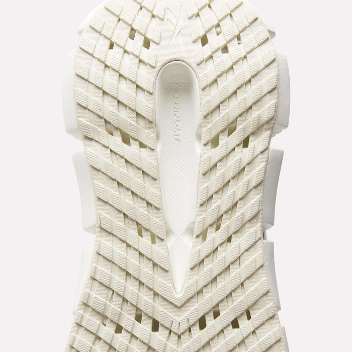 Close-up of the sole of Reebok Women's FloatZig 2 Running Shoes, featuring a white geometric grid tread and textured surface viewed from below, with subtle branding in the center to highlight its energy-returning cushioning.