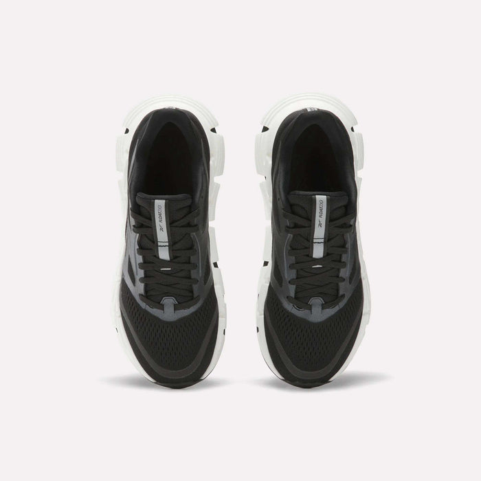 A pair of Women's FloatZig 2 Running Shoes by Reebok in black and white, shown from above with black laces, mesh uppers, and thick white soles featuring Superfloat+ cushioning on a plain white background.