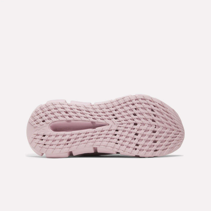 The image shows the bottom view of a pink Women's FloatZig 2 Running Shoe by Reebok, featuring a textured, grid-like sole pattern for grip and flexibility with Superfloat+ cushioning for enhanced comfort.