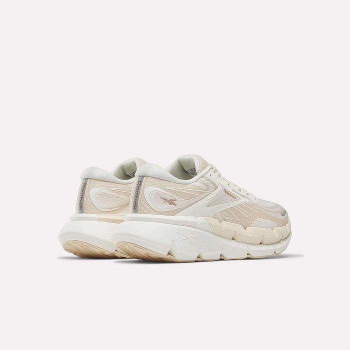 A pair of Women's FloatZig Double Running Shoes by Reebok in chunky off-white with beige accents and thick, textured soles—perfect for max-cushioned miles—viewed from the back left side against a plain light background.