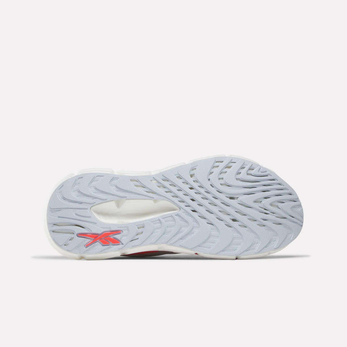 The image shows the underside of Reebok Women's FloatZig Double Running Shoes, featuring a light gray, textured sole with a swirling tread for support and a red Reebok logo near the heel. The background is plain white.