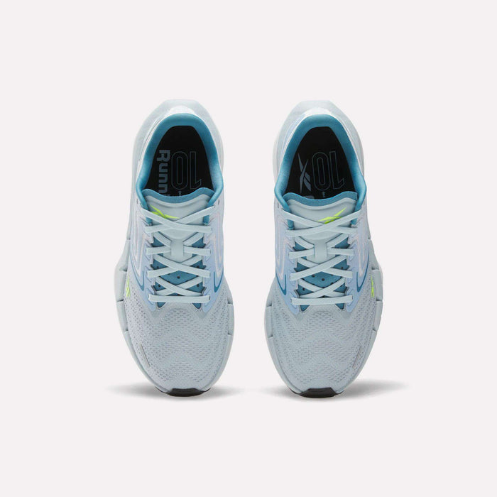Top view of Reebok Women's FloatZig Tread Running Shoes in light blue with white laces, breathable mesh, and a yellow accent on the right tongue, side by side on a plain white background—ideal for treadmill workouts.