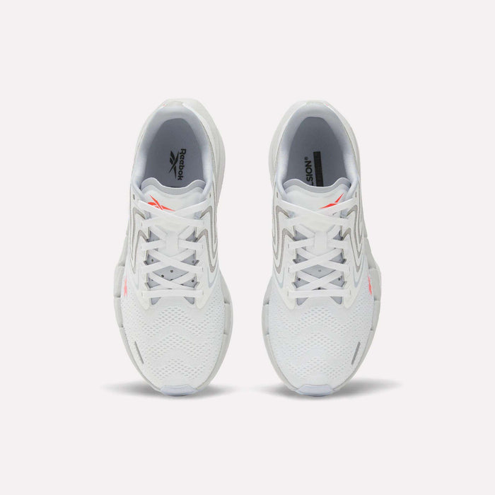 A pair of Women's FloatZig Tread Running Shoes by Reebok, viewed from above, with a breathable mesh upper, grey accents, and small orange Reebok logos on each tongue—perfect for treadmill workouts.