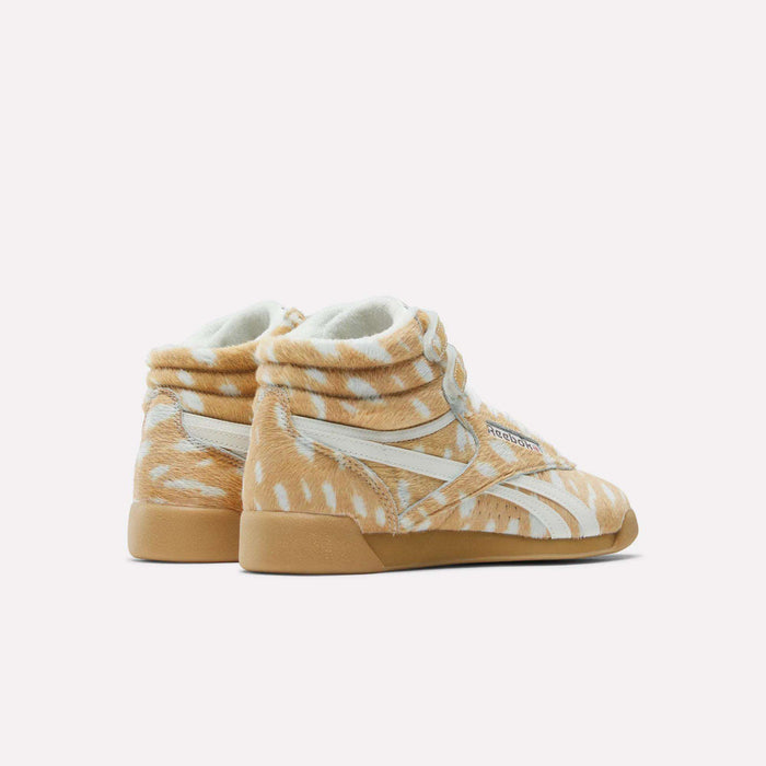 Reebok Women's Freestyle Hi Shoes in tan and white animal-print with white stripes and gum soles evoke an 80s fitness classic, shown on a plain white background.