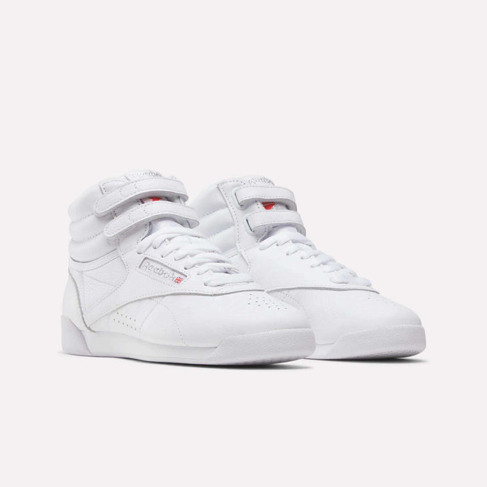 Reebok Women's Freestyle Hi Shoes in white feature high-tops, velcro straps, and laces—ideal for fitness—shown on a plain white background.