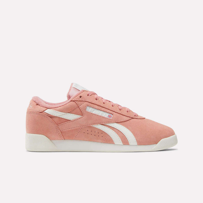 The Women's Freestyle Lo Shoes by Reebok feature pink suede with white accents, a side stripe, and logo. Shown against a plain light background, these retro sneakers combine classic style and comfort.