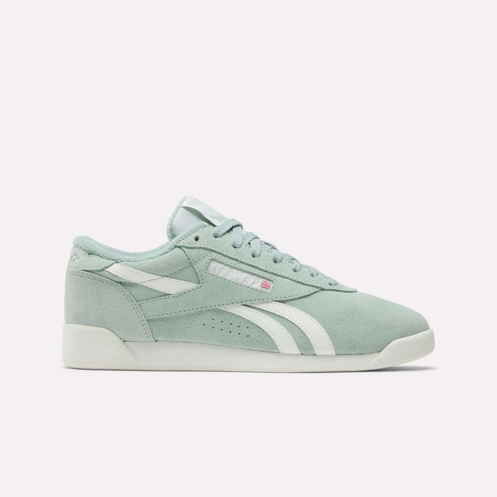 The Reebok Women's Freestyle Lo Shoes feature pastel green suede, white side stripes and sole, plus matching green laces for classic retro style, shown here on a plain white background.