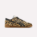 The Women's Freestyle Lo Shoes by Reebok feature a tan and black leopard print pony hair upper with black laces, black side stripes, and a light brown gum sole, drawing inspiration from classic '80s fitness trainers. Displayed on a plain white background.