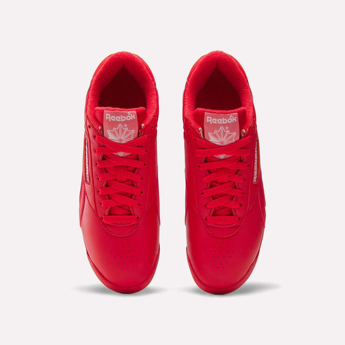 Top view of Reebok Women's Freestyle Lo Shoes in bright red with matching laces, a maple leaf logo on the tongue, and white branding, set on a plain white background—an eye-catching option for women.