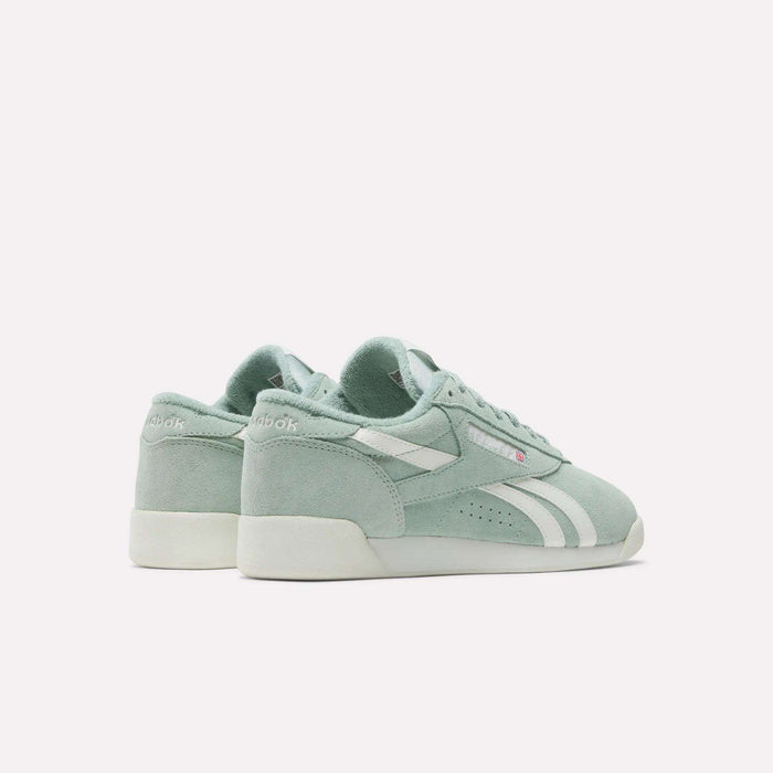 The image features Reebok Women's Freestyle Lo Shoes in light green with white accents and soles, displayed from the back and side angles against a plain white background.