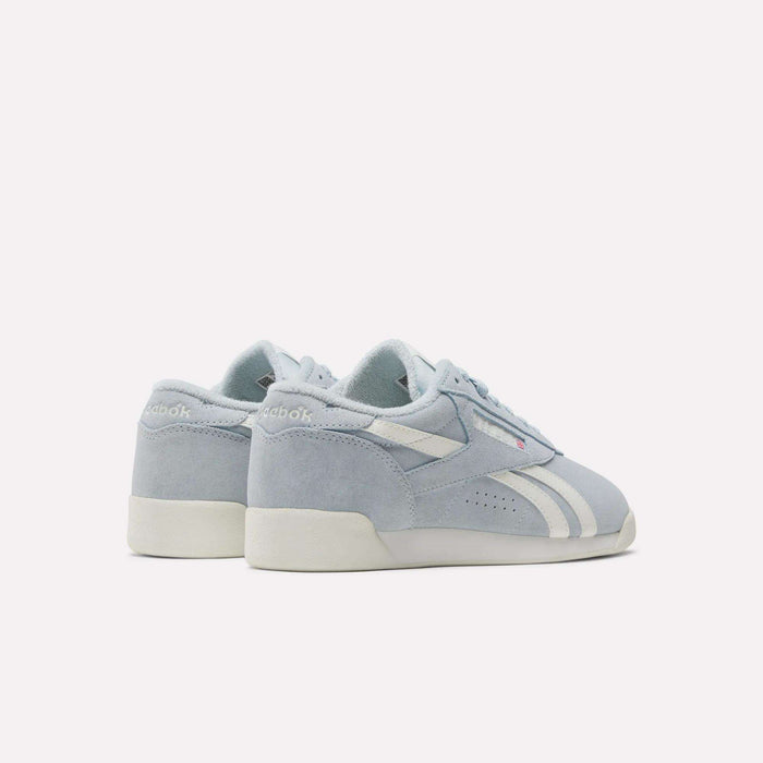 Women's Freestyle Lo Shoes by Reebok, in light blue with suede accents, white soles, and side stripes, are shown from the back and side on a plain white background.