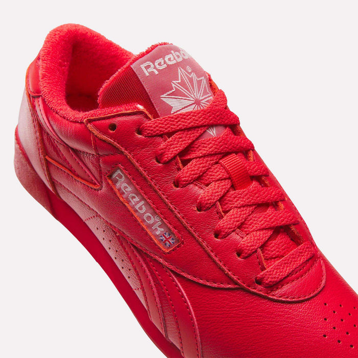 The Women's Freestyle Lo Shoes by Reebok offer a stylish design with a white logo, perfect for women seeking trendy leather footwear.