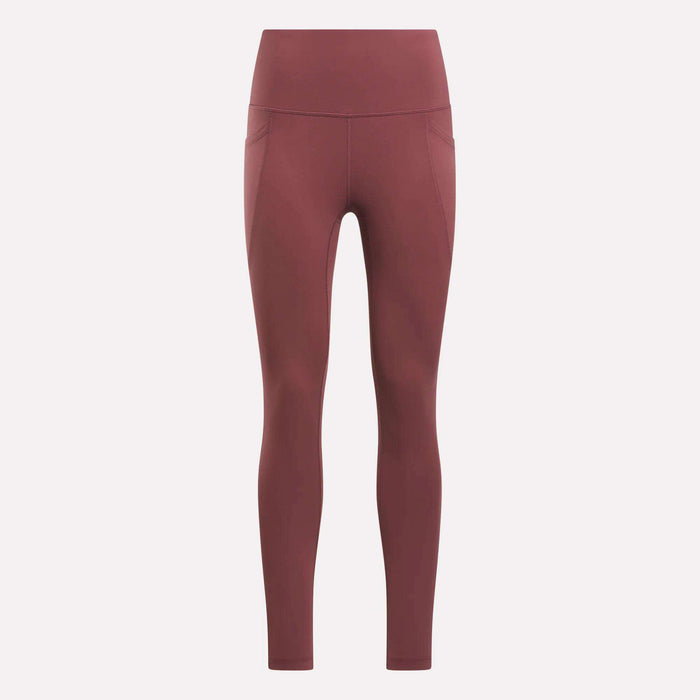 Reebok Women's High-Rise Tights in a muted reddish-brown feature side pockets, visible seam details, and a high-rise waistband. These full-length training tights are displayed on a plain light background.