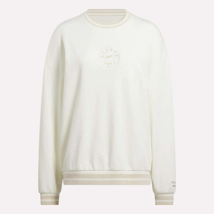 The Women's Lawn Club Crew Sweatshirt by Reebok is a cozy white fleece crewneck with ribbed cuffs and hem, featuring an embroidered circular logo and text on the chest plus a small sleeve logo for subtle style.