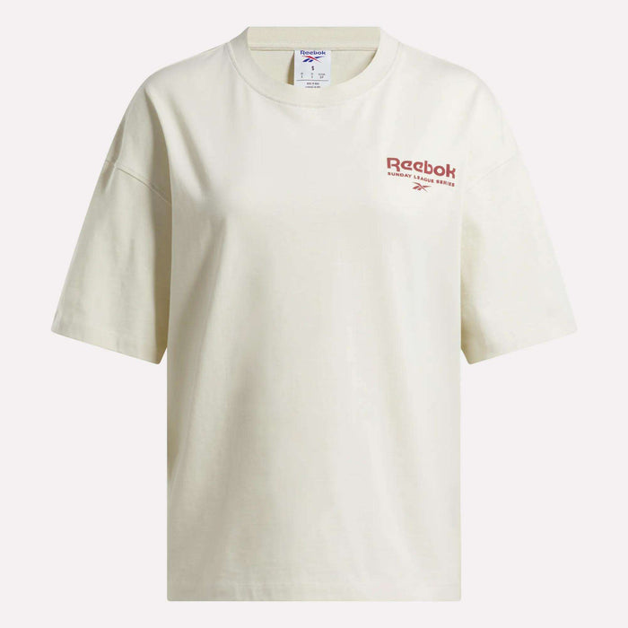 The Reebok Women's League Club Graphic T-Shirt is an off-white cotton tee with a relaxed fit, featuring the red Reebok logo and text on the left chest.