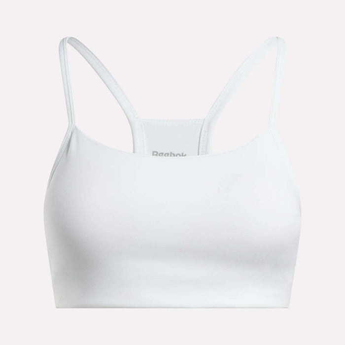 The Reebok Women's Low-Impact Sports Bra features thin shoulder straps and a racerback design in white, ideal for light-impact workouts and shown against a light background.