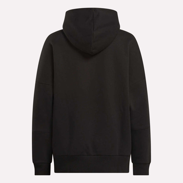 The Reebok Women's Lux Hoodie is shown from the back in plain black, with an oversized fit, long sleeves, and the hood up. It has no visible logos or patterns—ideal for a relaxed, cozy look.