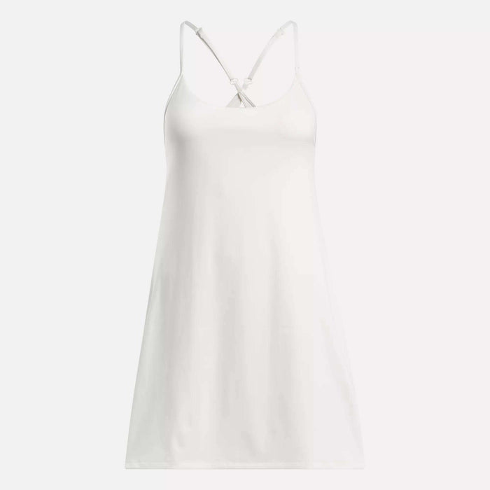 The Reebok Women's Lux Strappy Dress is a sleeveless white slip dress with thin adjustable straps and a V-neckline, designed for comfort and a perfect fit, shown on a plain background.
