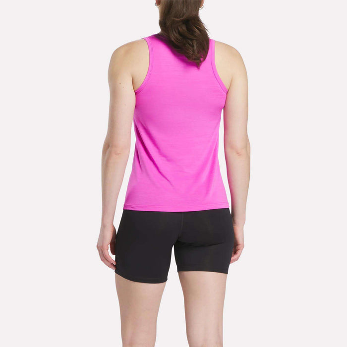 A woman faces away from the camera wearing a Reebok Women's Marled Performance Tank Top in bright pink and black shorts, set against a plain white background to showcase this stylish activewear piece.