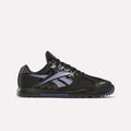 The Reebok Women's Nano 2.0 Training Shoes are black with purple accents, mesh panels, and a textured sole, ideal for functional fitness. Featuring the iconic logo on the side, they're shown on a white background.