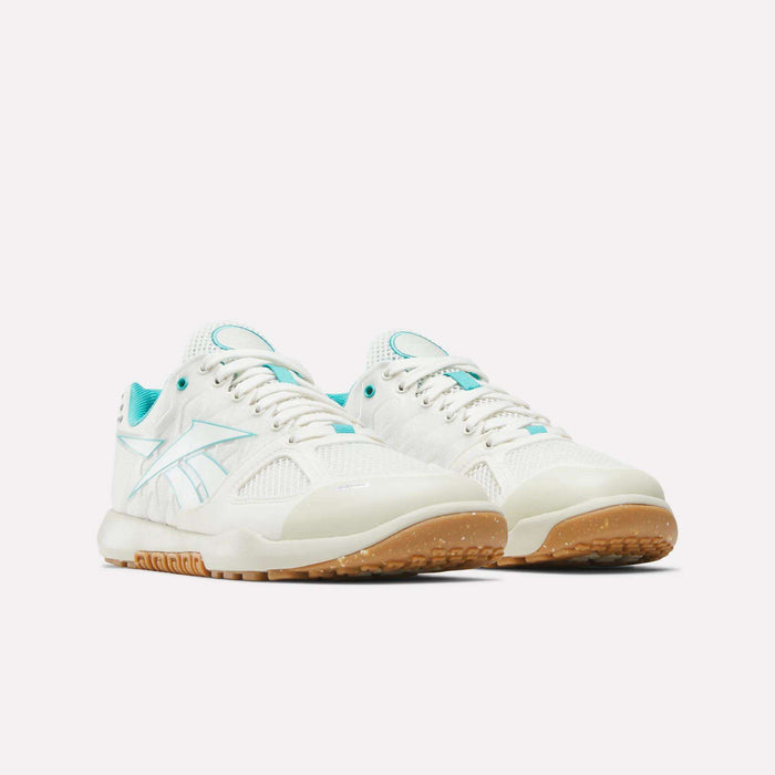 The Women’s Nano 2.0 Training Shoes by Reebok are showcased on a plain white background, featuring white uppers with teal accents and gum-colored soles—delivering an ideal blend of style and performance for functional fitness.