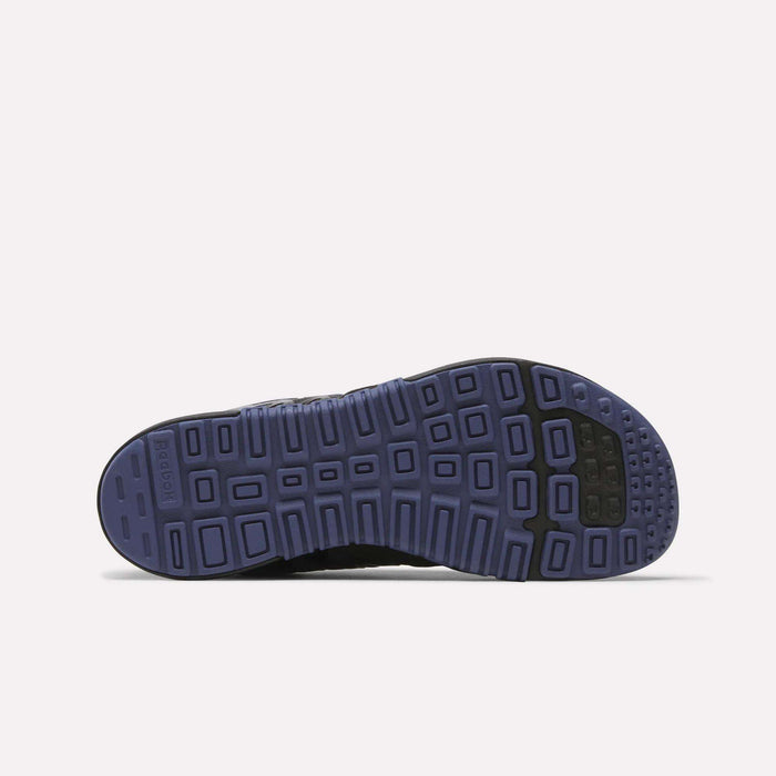 The image displays the bottom view of Reebok Women's Nano 2.0 Training Shoes, featuring a purple rubber sole with a grid-like tread and black accents on the toe and heel, designed for functional fitness. Background is plain white.