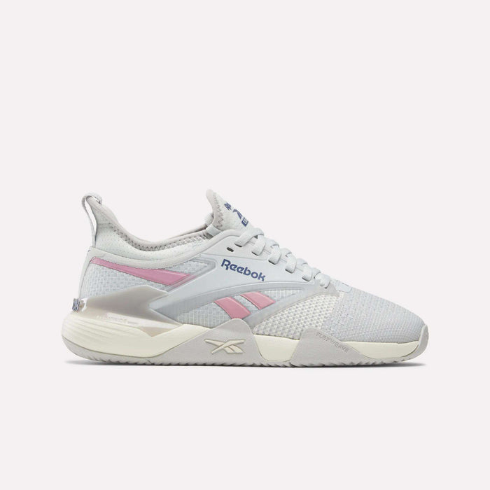 The Reebok Women's Nano Court Training Shoes feature a white mesh upper with light pink and grey accents, lace-up closure, chunky Griptonite rubber outsole, and the Reebok logo on the side and tongue.