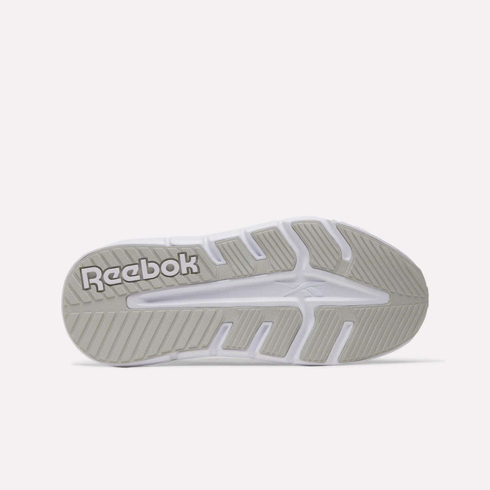 The image shows the underside of a white Reebok sole with light gray tread and "Reebok" in raised letters, emphasizing the durability of the Women's Nano Gym 2.0 Training Shoes.