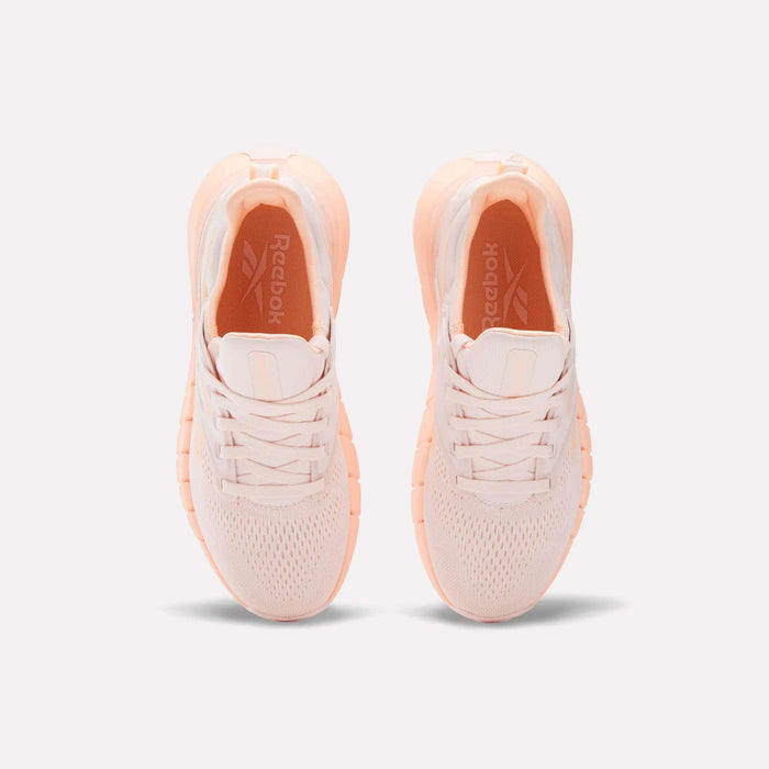 The Women's Nano Gym Training Shoes from Reebok are pink and white, ideal for your next workout.