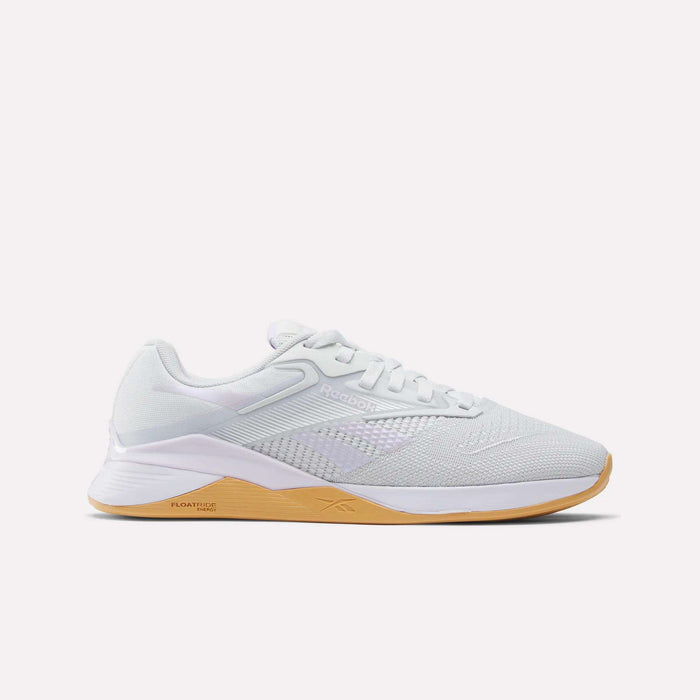 The Reebok Women's Nano X4 Training Shoes feature a breathable mesh upper, white laces, and a light brown gum sole with Floatride Energy Foam for responsive cushioning. Displayed on a plain white background.
